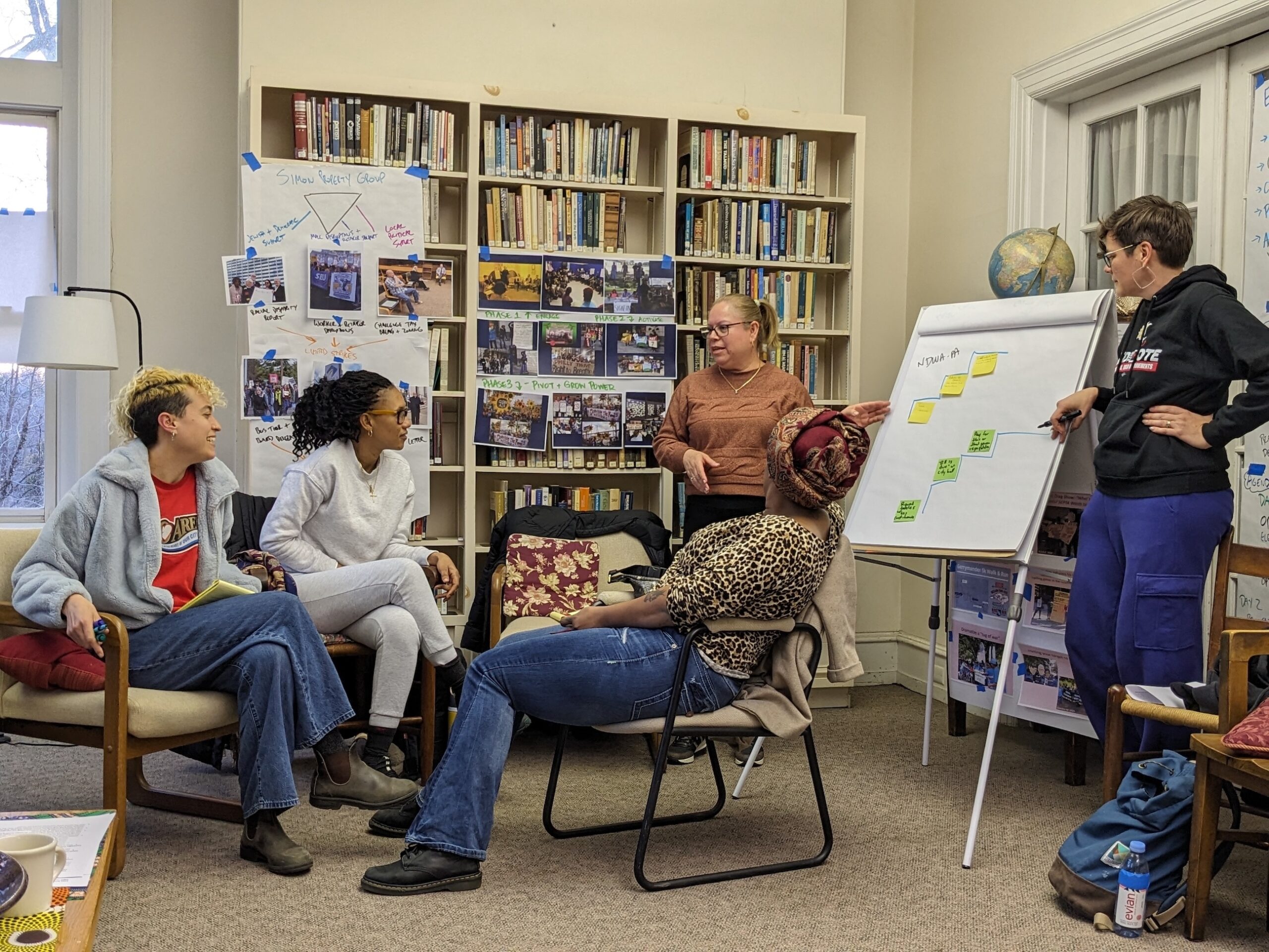 A group of standing masked workshop participants making intentional poses during a training.